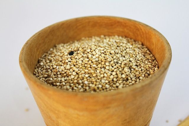 A photo of amaranth grain inside  a wooden jar.