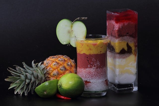 A picture of some fruits and juices in glasses.
