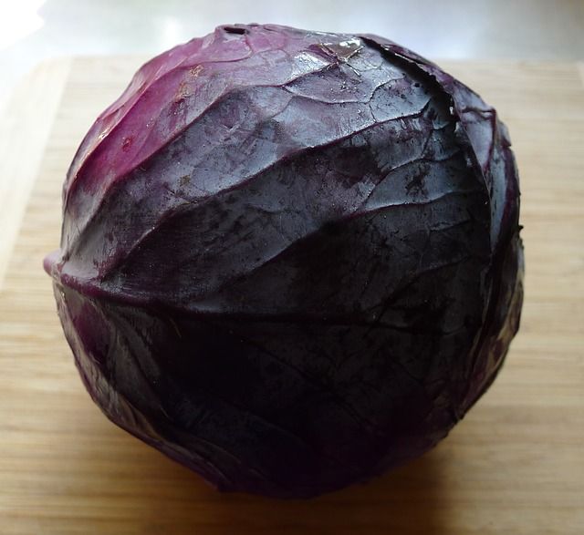 A photo of a red cabbage on a table.