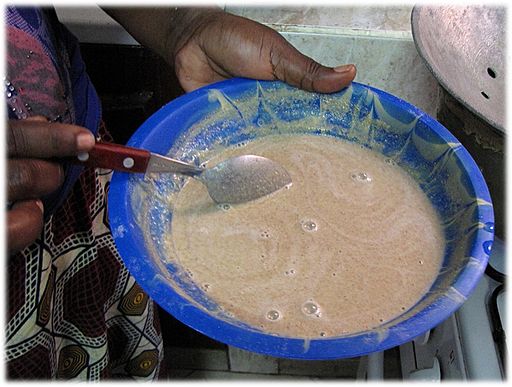 A photo of a person mixing millet flour on a plate